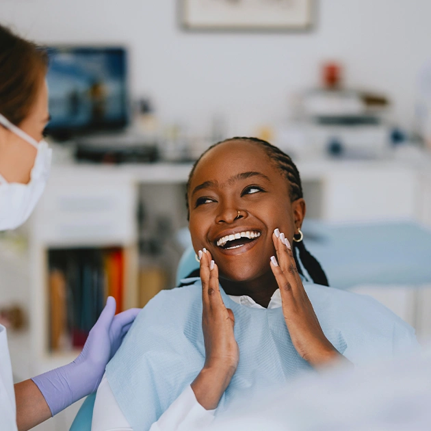 Young patient smiling during dental examination in modern dental office with dentist.